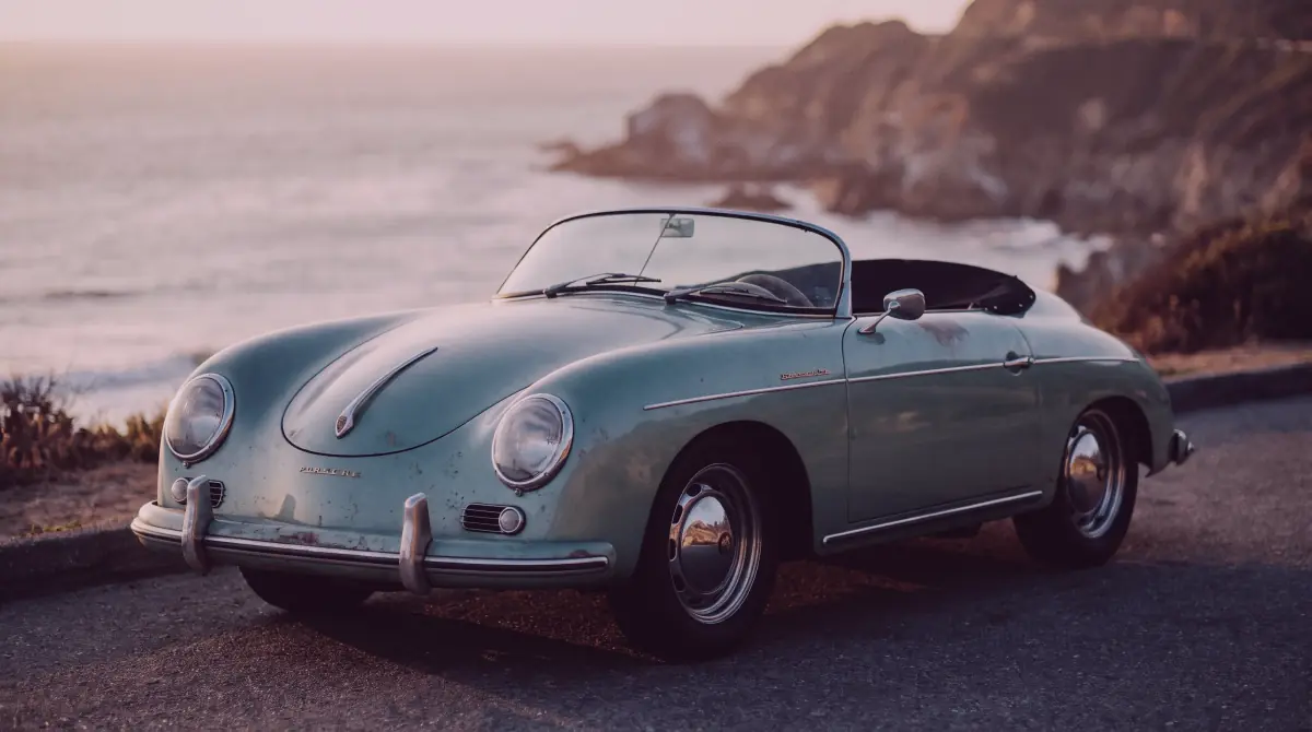 Vintage car on a coastal road at golden hour