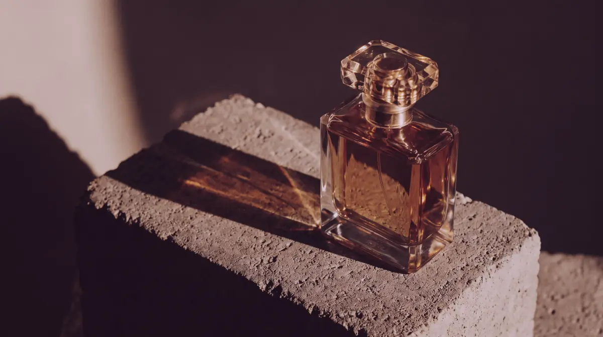 Luxury perfume bottle photographed in dramatic golden-hour light