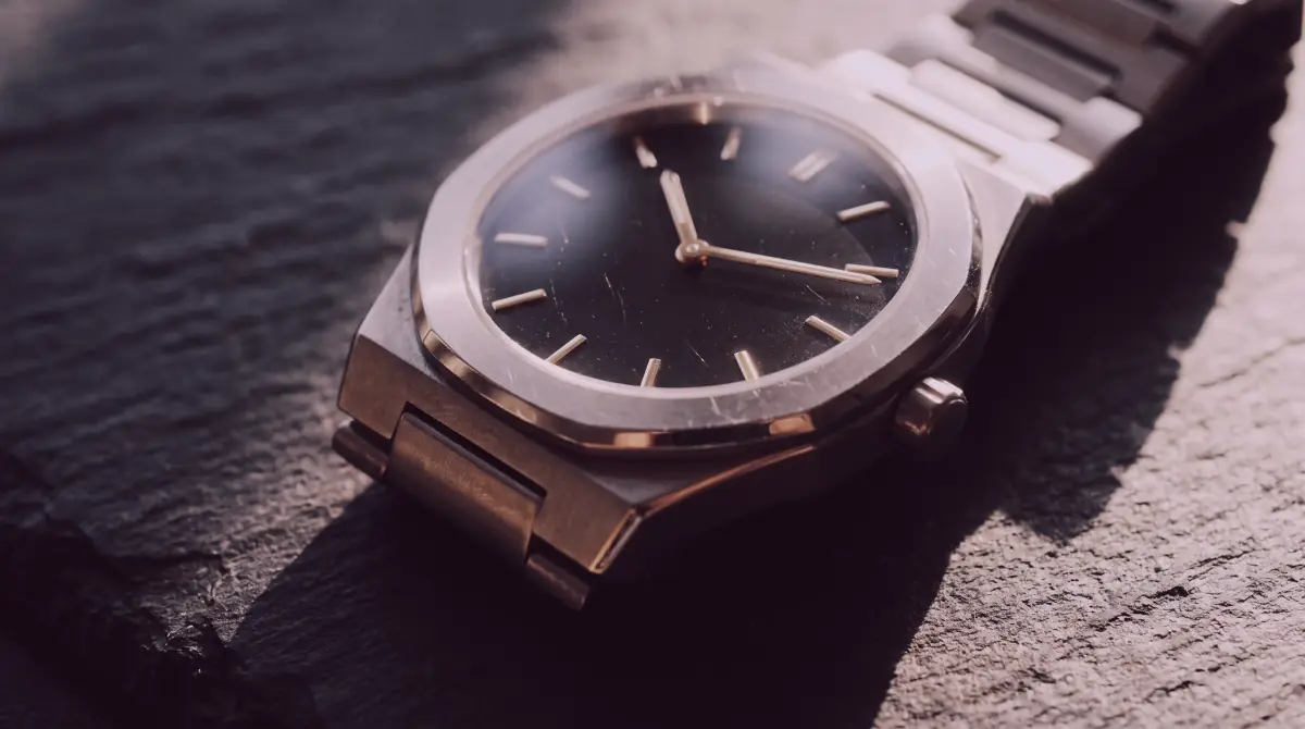 Luxury watch on dark stone under dramatic directional light
