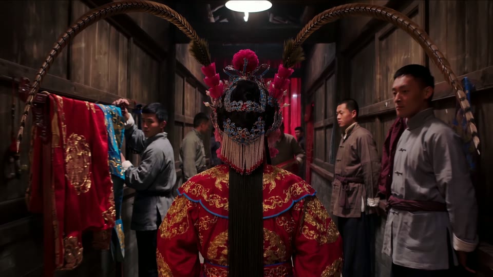 12 seconds in: the backstage corridor, stagehands flattening against the walls as she passes