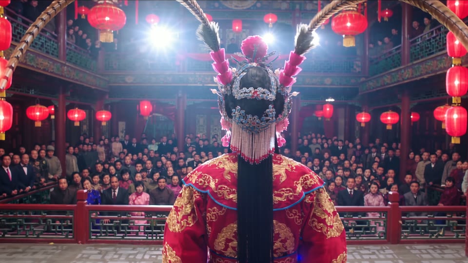 24 seconds in: through the curtain into stage light, the lantern-lit house opening up behind